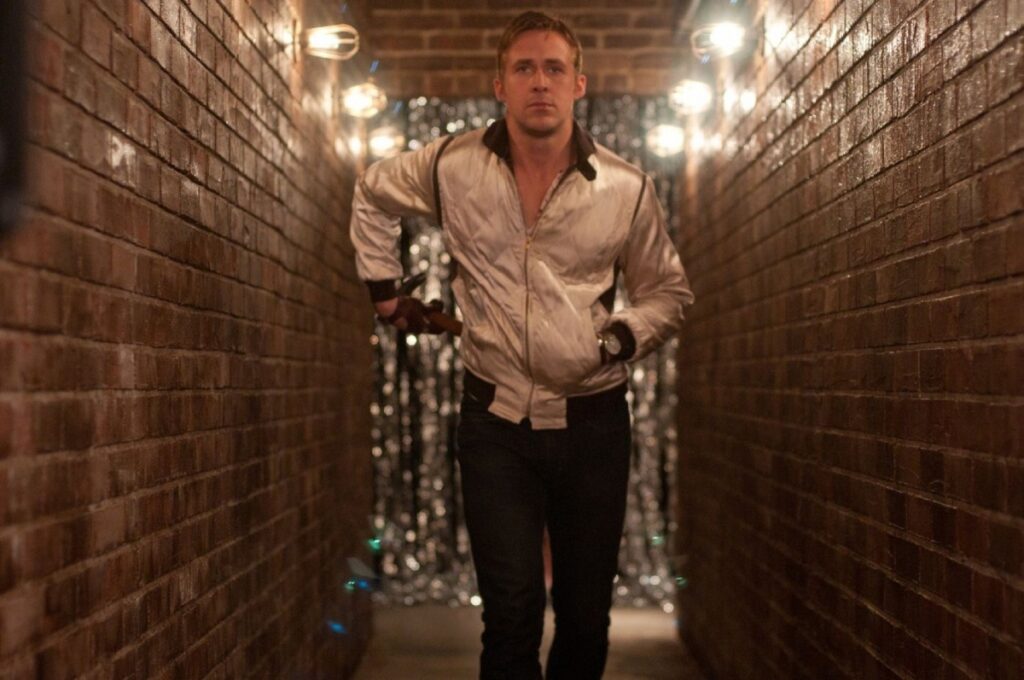 Ryan Gosling wearing the iconic scorpion jacket in the movie Drive